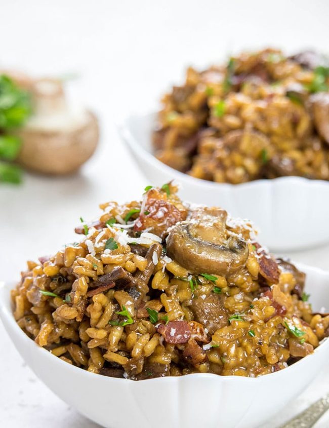 Two Bowls of Easy Mushroom & Bacon Risotto sprinkled with grated cheese and parsley
