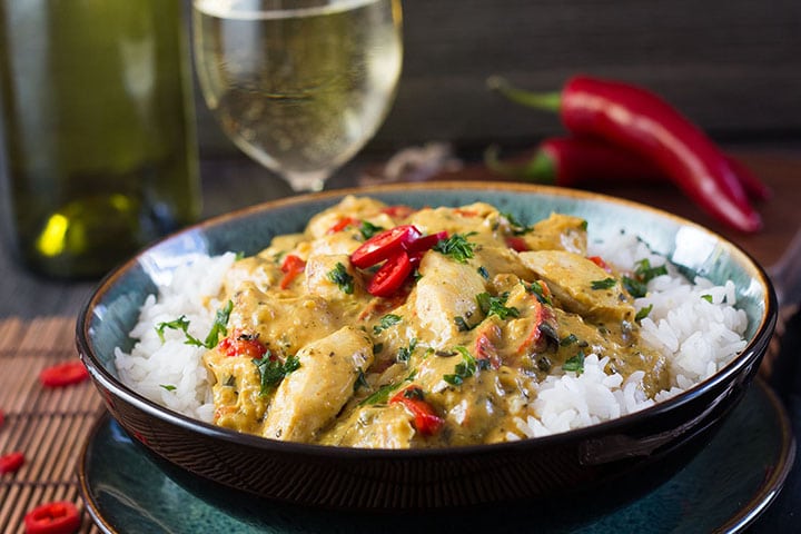 Thai Panang Chicken Curry on a bed of steamed rice and garnished with red chillies.
