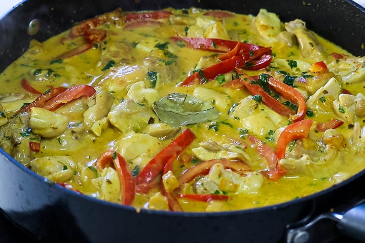 The herbs and lime leaves added to the pan with the curry