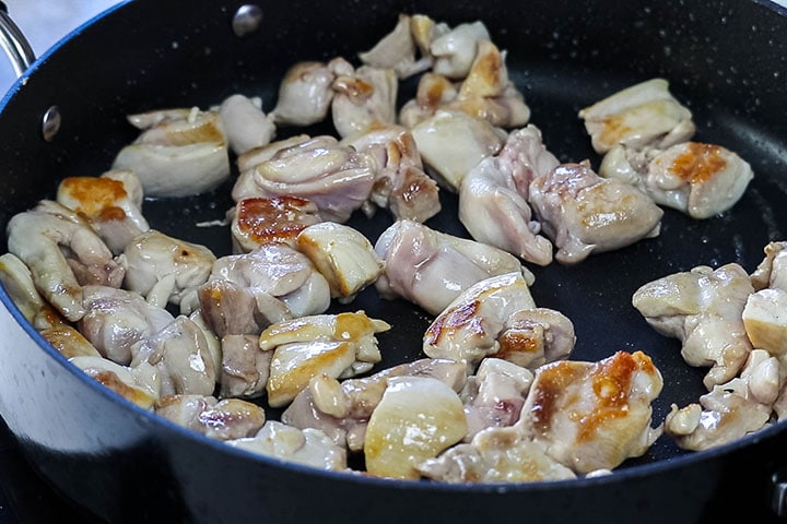 chicken cut into bite-sized pieces cooking in the pan