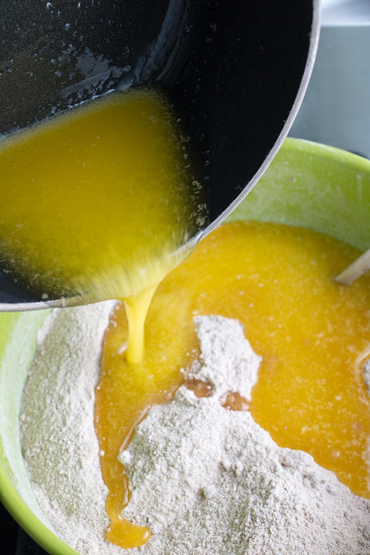 The melted butter being poured onto the sugar mixture.