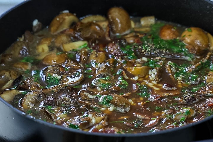 The stock, parsley and seasoning added to the pan