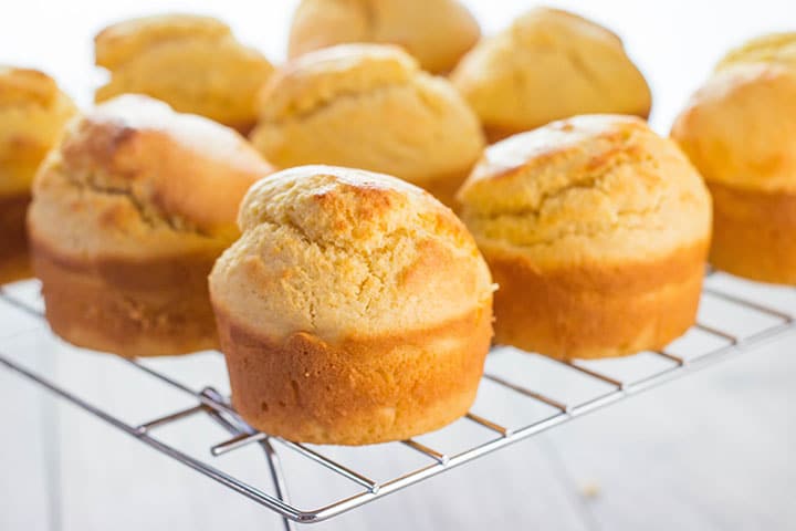 Freshly baked corn muffins cooling on a cooling rack