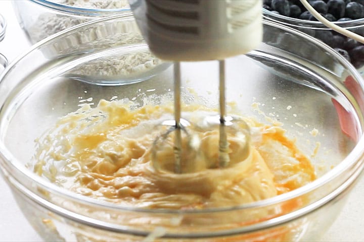 The wet ingredients being mixed with the sugar