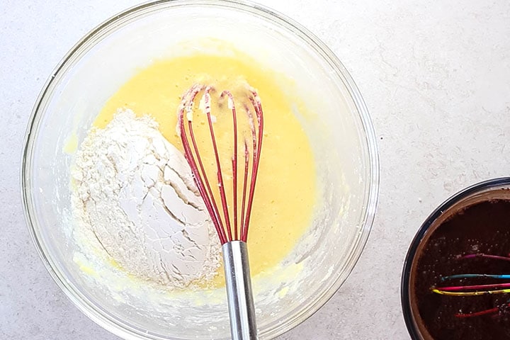 a scoop of the flour mixture added to the wet ingredients 