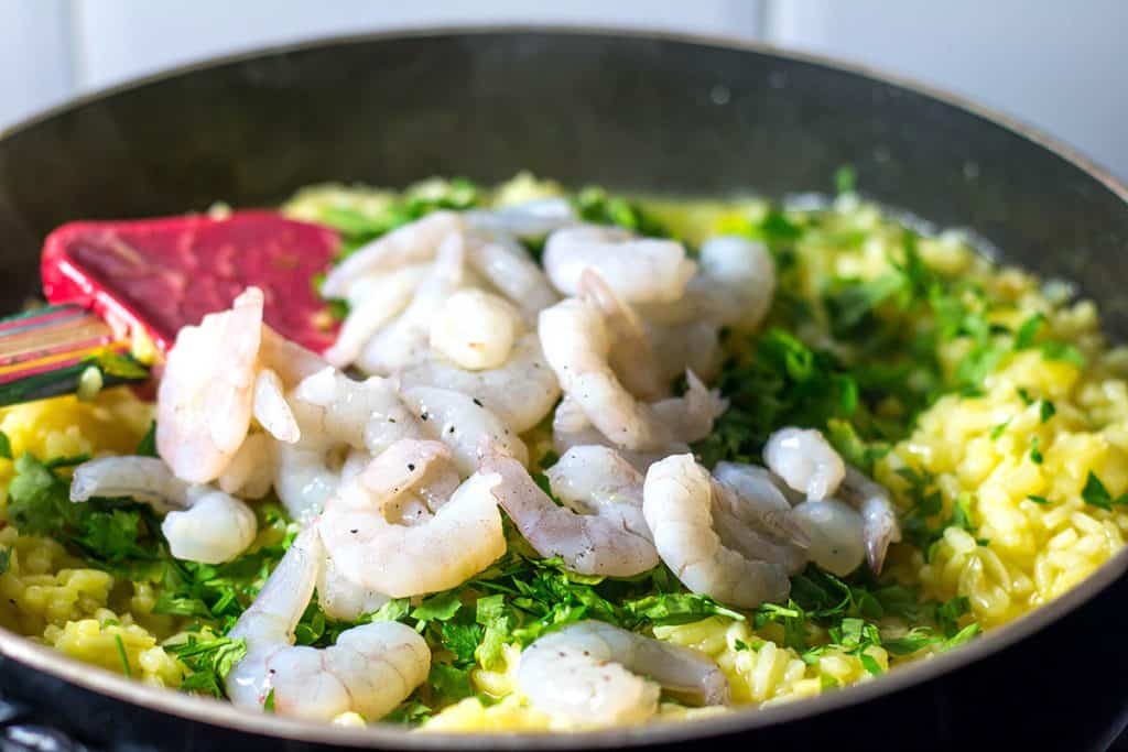 the shrimp and herbs added to the pan with the reice mixture
