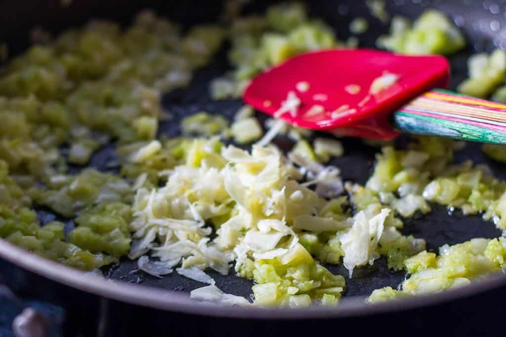 omions and celery cooking in a pan