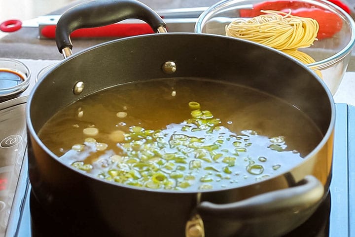 the green onions added to the stock in the pot