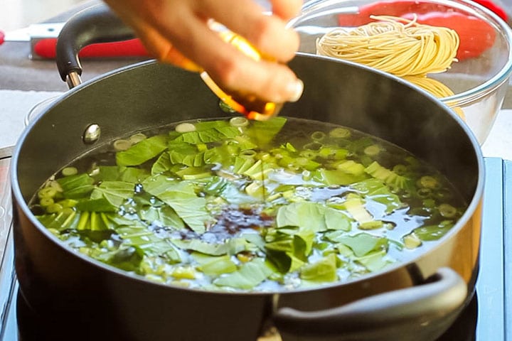 The soup with the soy sauces and oyster sauce added to the stock in the pan