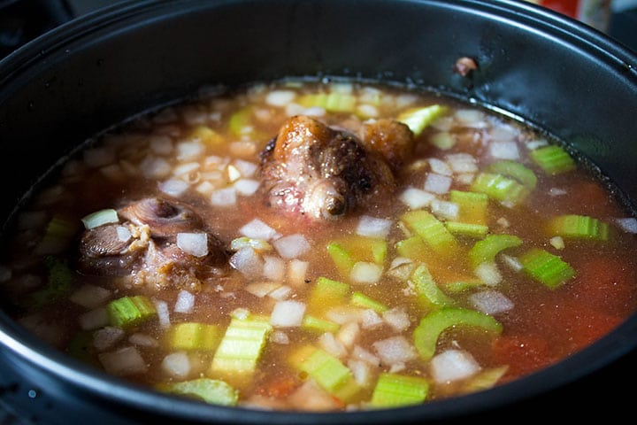 the stock and tomato paste added to added to the slow cooker with the vegetables and oxtail