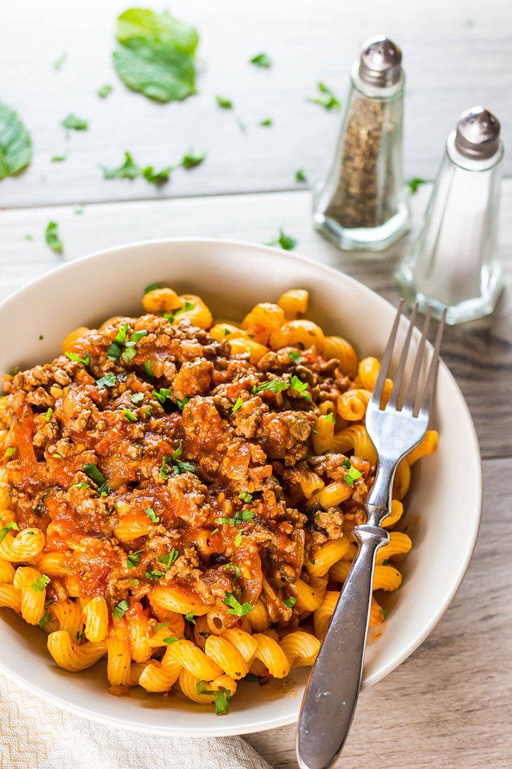A plate of curly pasta topped high with Greek Style Meat Sauce {Makaronia Me Kima}
