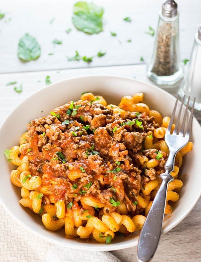 A plate of curly pasta topped high with Greek Style Meat Sauce