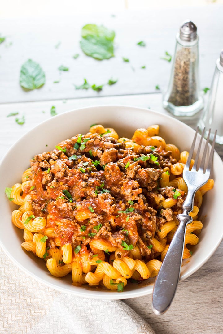 A plate of curly pasta topped high with Greek Style Meat Sauce
