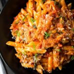 A big plate of Pasta Alla Norma {Pasta with Eggplant Sauce} sprinkled with cheese and scattered with sliced basil