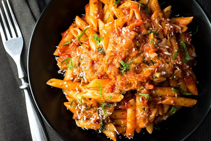 A big plate of Pasta with Eggplant Sauce {Pasta Alla Norma} sprinkled with cheese and scattered with sliced basil