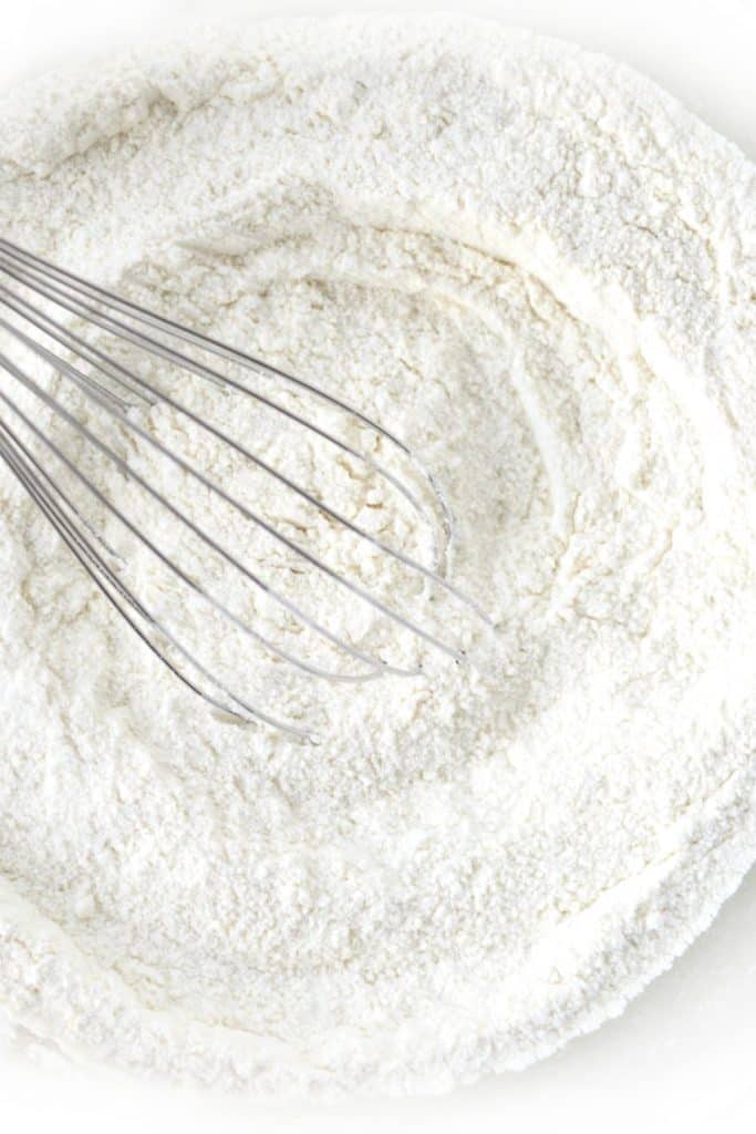 a flour mixture in a bowl with a whisk