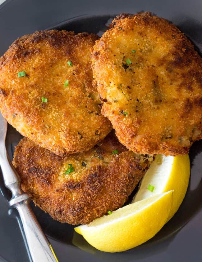 a plate of three golden brown crab cakes