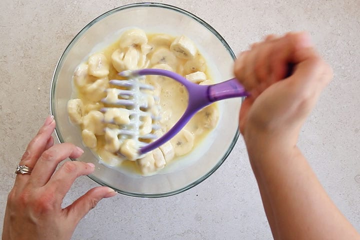 Mashing the bananas and condensed milk together with a potato masher