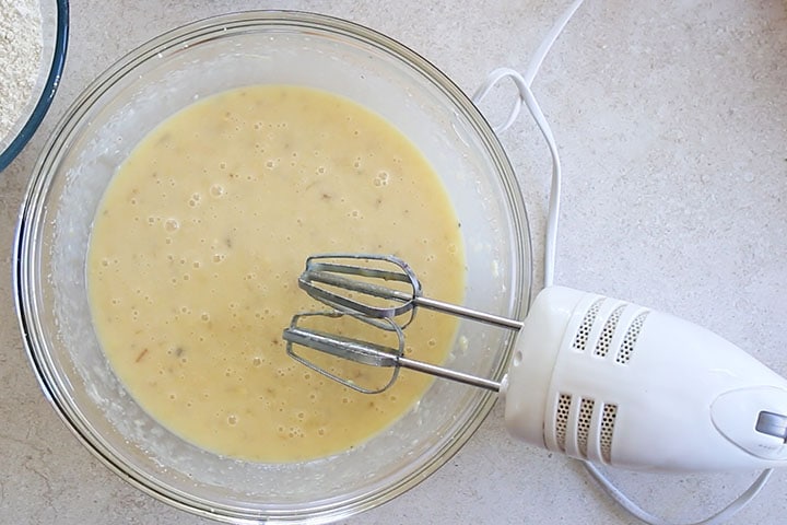 A glass bowl with the butter sugar mixture and the banana mixture combined 