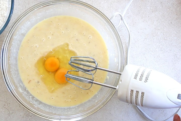 A glass bowl with the eggs added to the batter