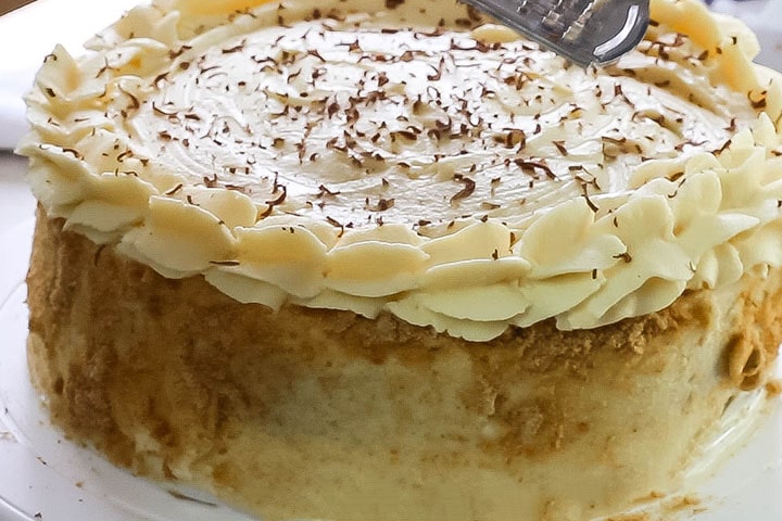 Chocolate being grated over the top of the cake