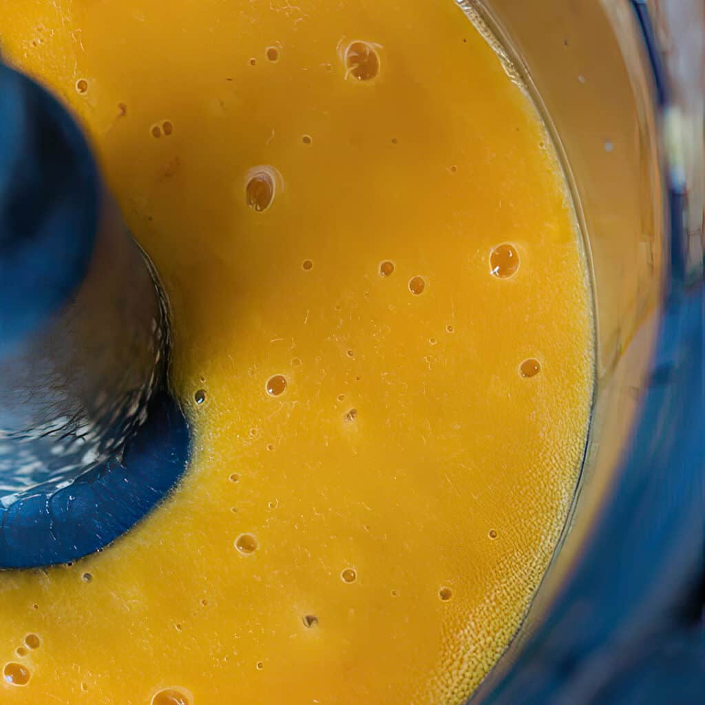 The pureed peaches in a food processor bowl