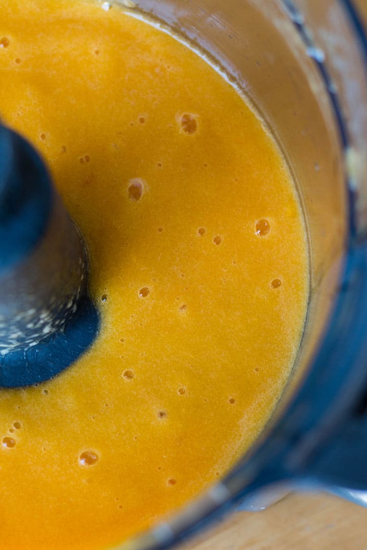 The pureed peaches in a food processor bowl