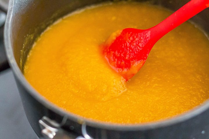 The pureed peaches cooked down in a sauce pan.