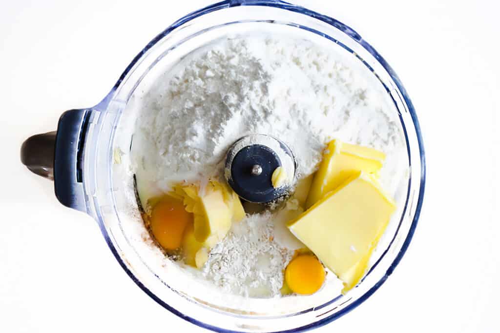 All of the cake ingredients added to a food processor bowl