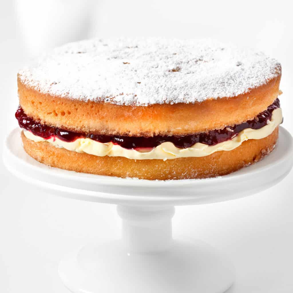 a close up image of a Victoria sponge cake topped with powdered sugar