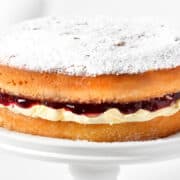 a close up image of a Victoria sponge cake topped with powdered sugar