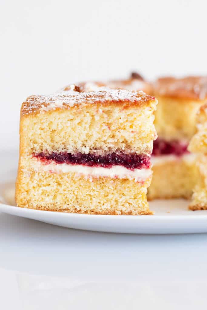 a slice of Victoria Sponge Cake with more slices in the background.