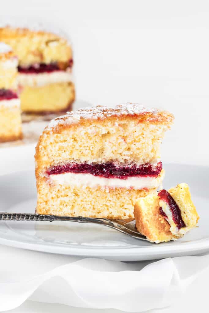 a slice of cake with a forkful of the Victoria Sponge Cake on the plate.