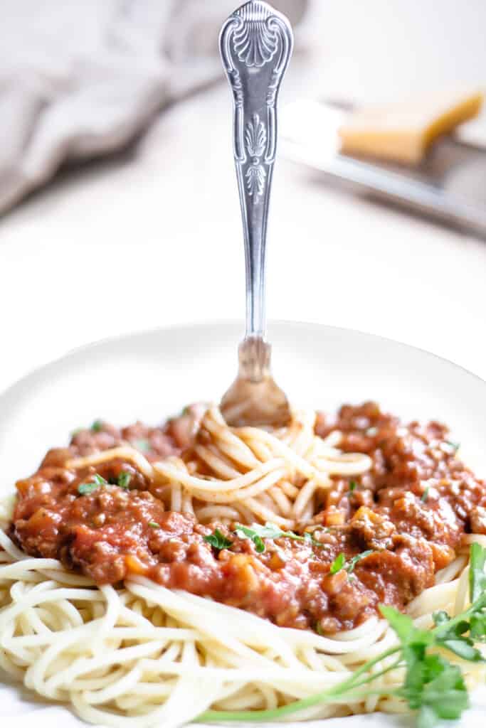 A fork twirling the Spaghetti Bolognese on a plate