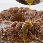 Caramel Apple Bundt Cake with the caramel sauce being poured over it