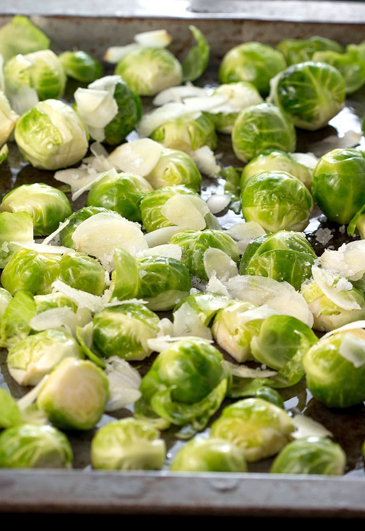 Brussels sprouts in a pan with thinly sliced garlic