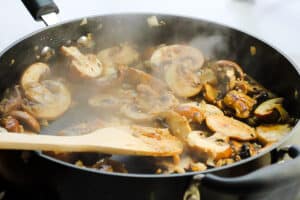 Mushrooms cooking in a pan.