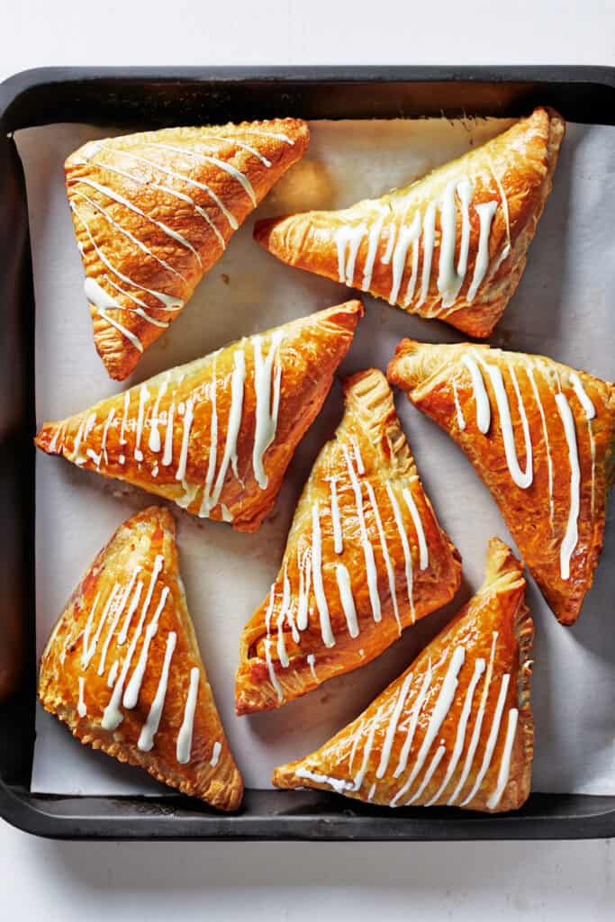 the puff pastry apple turnovers on the pan finished with the glaze.