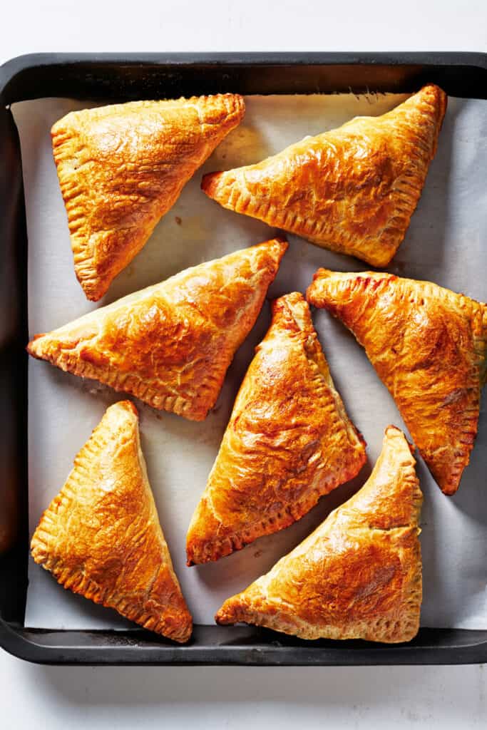 the baked puff pastry apple turnovers on a pan lined with baking paper.