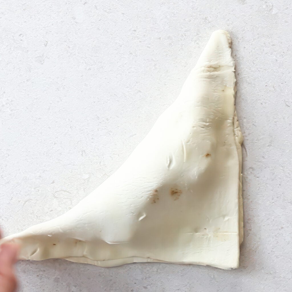 the puff pastry folded over the apple mixture to form a triangle shape. 