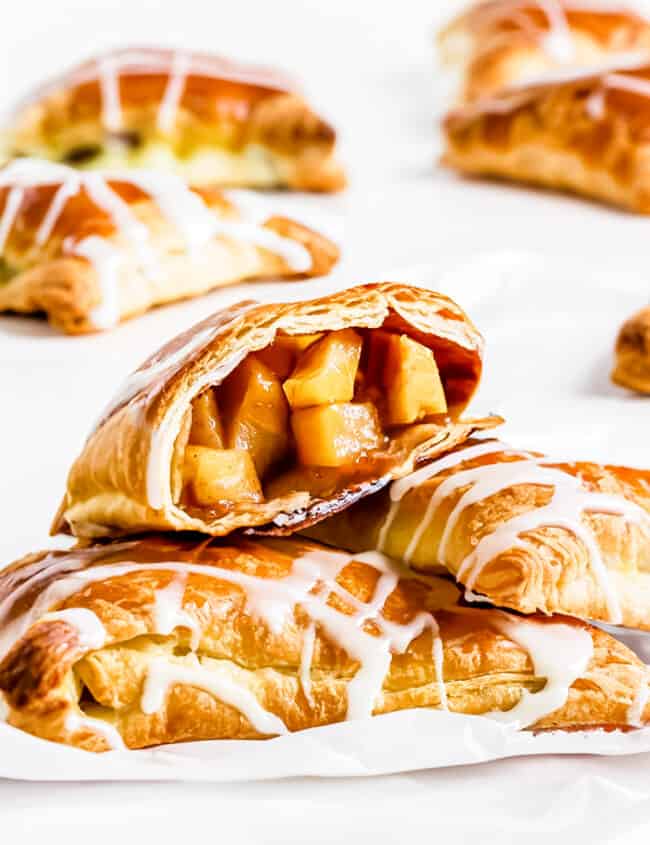 apple turnovers on a plate with one broken open to show the filling