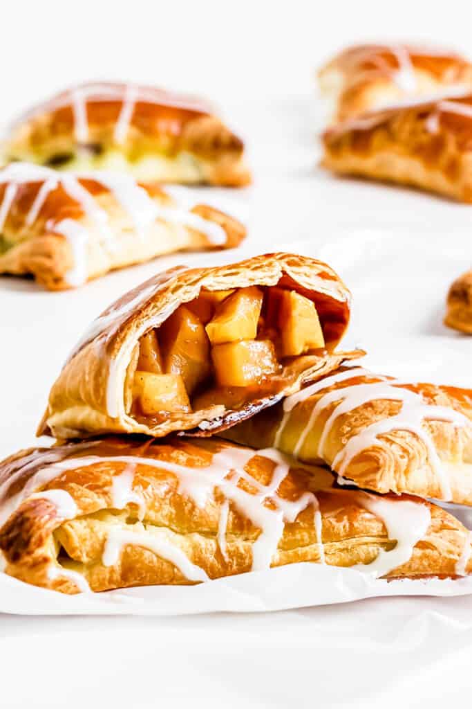 apple turnovers on a plate with one broken open to show the filling