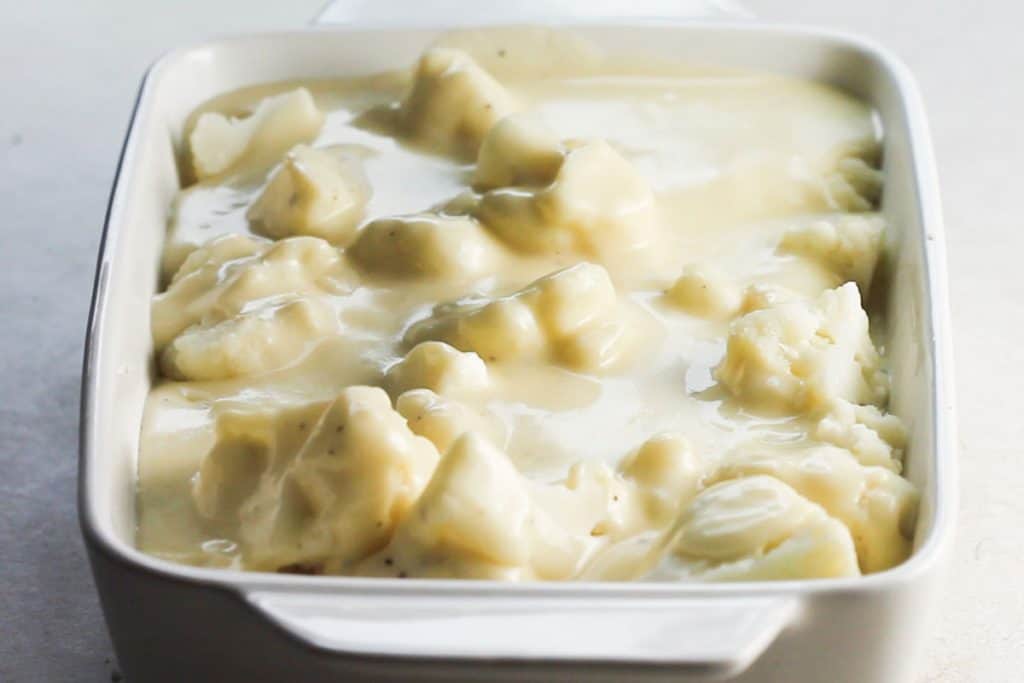 the Cheesy Cauliflower bake ready to be topped with cheese and placed in the oven