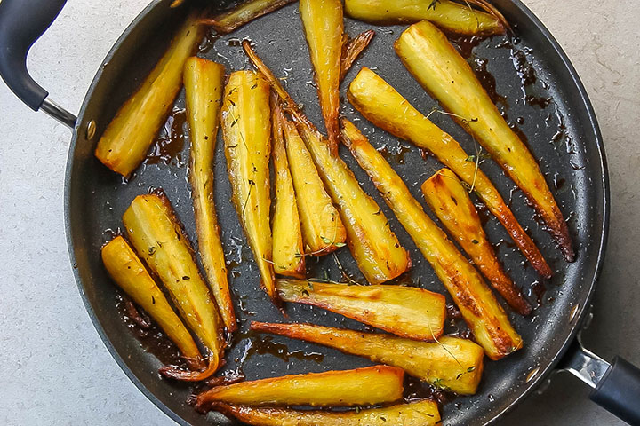 Honey & Maple Roasted Parsnips golden and brown in a pan fresh from the oven