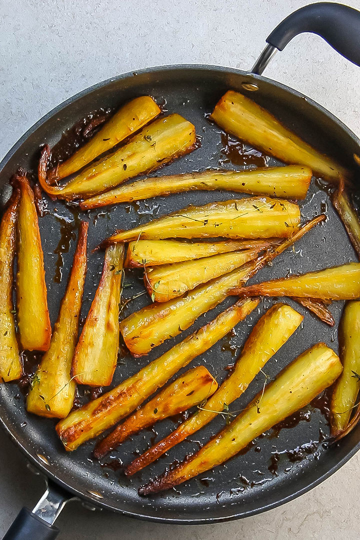 Honey & Maple Roasted Parsnips golden and brown in a pan fresh from the oven