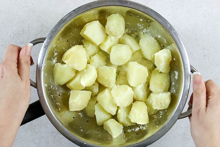 Potatoes in a strainer being shaken