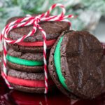 A stack of Homemade Oreo Christmas Cookies with one leaning against them