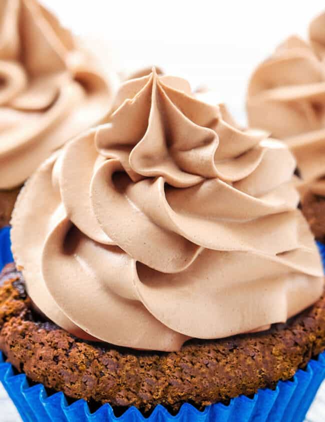 a close up of a cupcake topped with Chocolate Whipped Cream Frosting
