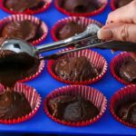 Batter being added to the cupcake pan with an ice cream scoop