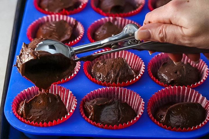 Batter being added to the cupcake pan with an ice cream scoop